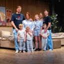 FamBedin taustalla olevat perheet pyjamissa esittelytilan sängyn edessä